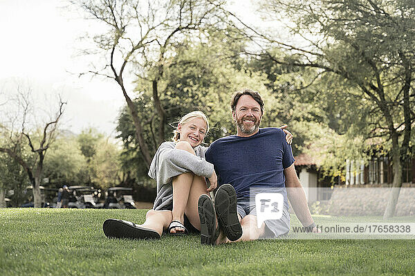 Father and Teenage Girl Smiling on a Grassy Lawn in Arizona