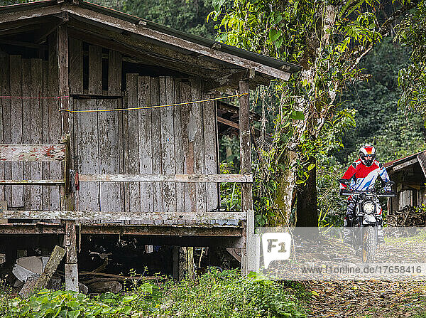 man riding his scrambler type motorcycle in north Thailand