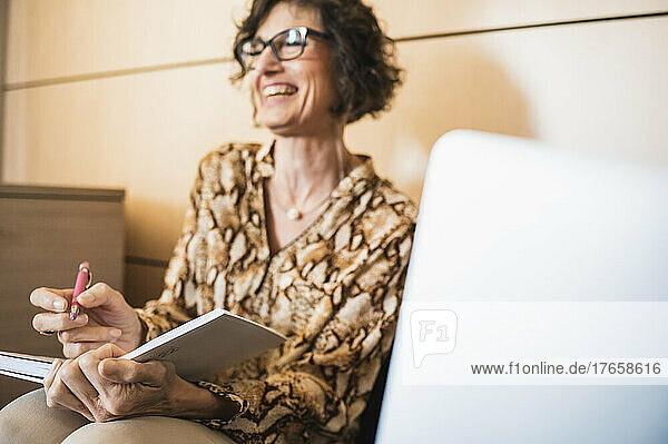 Senior woman laughing in a moment of relaxation in the office.