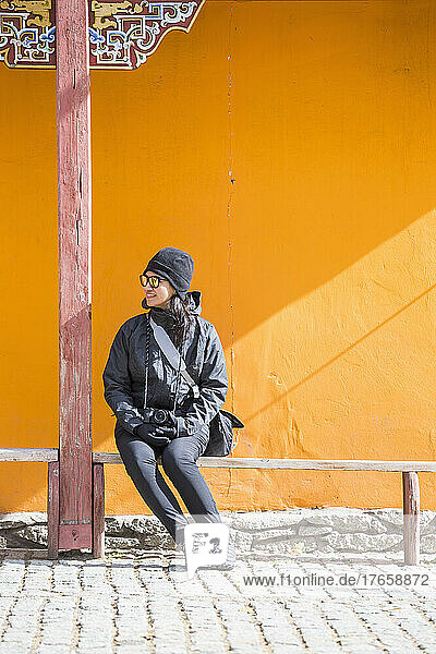 woman sitting on bench at temple in Ulaanbaatar / Mongolia