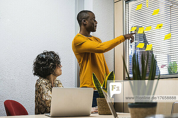 Senior woman and black young man preparing a project in an office.