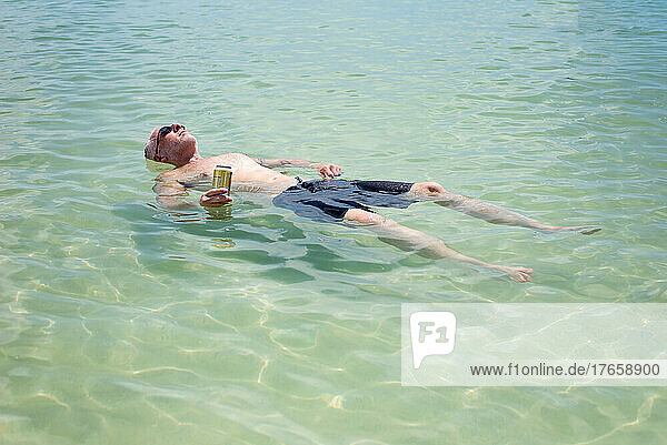 Adult man relaxing in the calm gulf waters on a hot summer day