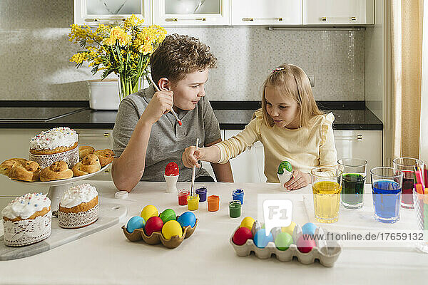 Cute brother and sister coloring Easter eggs.