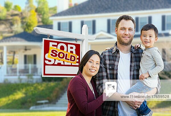 mixed-race chinese and caucasian parents and child in front of house and sold for sale real estate sign