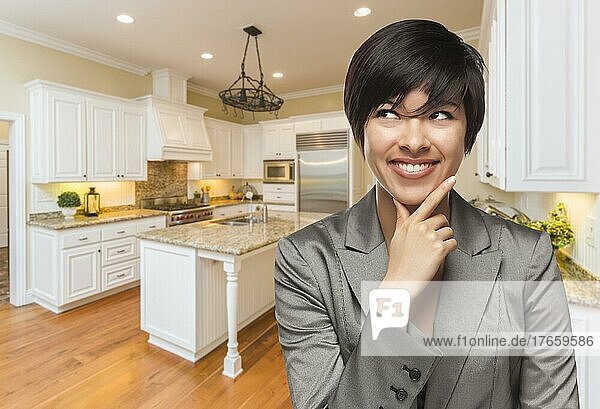 Hübsche gemischtrassige Frau blickt über die Schulter zurück in eine individuell gestaltete Küche