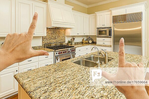 Weibliche Hände beim Einrahmen einer schönen individuellen Kücheneinrichtung