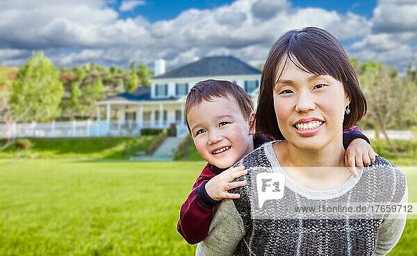 Chinese mother and mixed-race child in the front yard of custom house