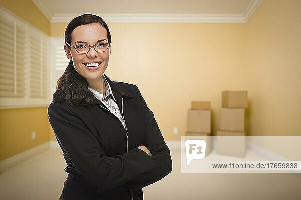 Attraktive selbstbewusste gemischtrassige Frau in leerem Raum mit Kisten
