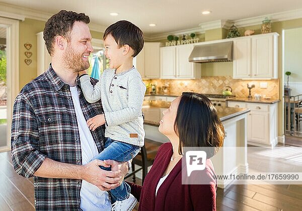 Young mixed-race caucasian and chinese family inside custom kitchen