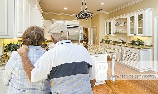 Glückliches älteres Ehepaar  das sich eine schöne  individuell gestaltete Küche ansieht