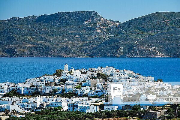 View of Plaka village with traditional Greek orthodox church and white painted houses and ocean coast. Milos island  Greece