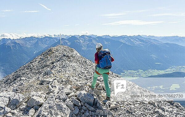 Wanderin mit Kletterhelm auf einem steilen Wanderweg  Gradwanderung  Hohe Munde  Mieminger Gebirge  Tirol  Österreich