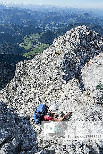 Wanderin klettert  Blick über Berglandschaft am Gipfel des Mitterhorn  Nuaracher Höhenweg  Loferer Steinberge  Tirol  Österreich  Europa