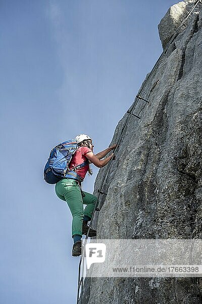 Wanderin steigt eine Leiter hinauf  Blick über Berglandschaft  Nuaracher Höhenweg  Loferer Steinberge  Tirol  Österreich  Europa