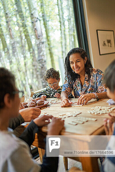 Glückliche Familie spielt Scrabble am Esstisch