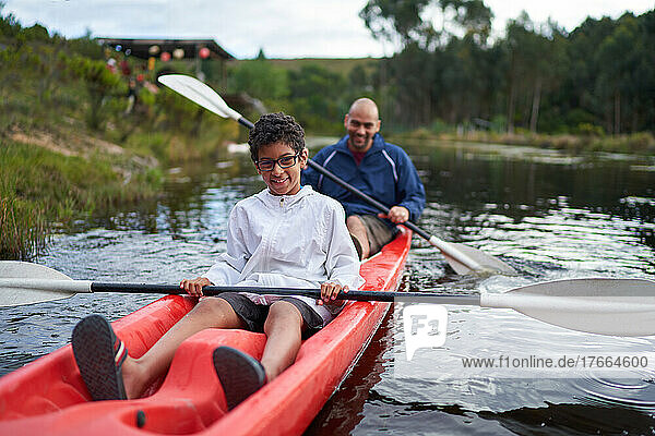 Portrait glücklicher Vater und Sohn beim Kajakfahren auf dem Fluss