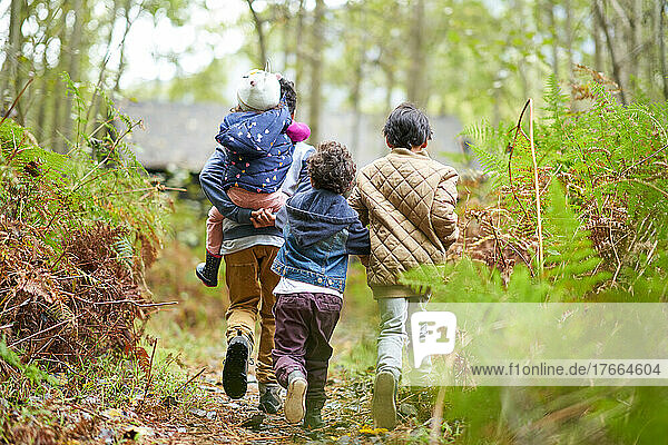 Brüder und Schwester wandern auf einem Pfad im Wald