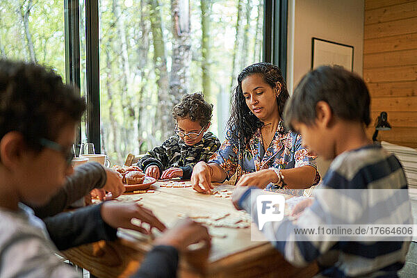 Family playing scrabble at cabin table