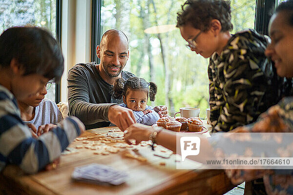 Familie spielt Scrabble am Esstisch