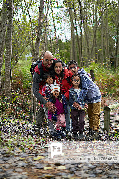 Portrait happy affectionate family hiking in woods