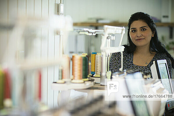 Portrait confident young female seamstress in studio