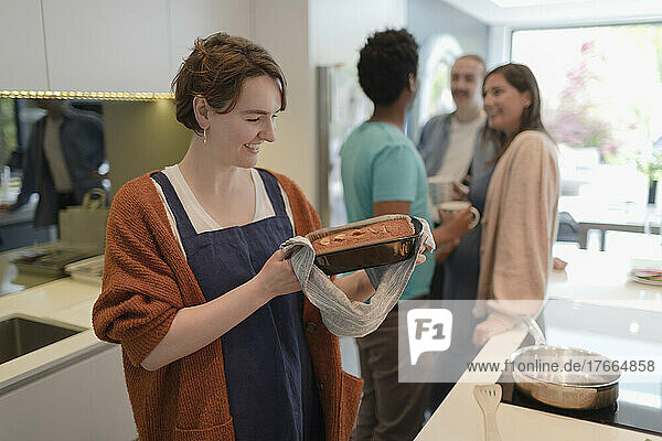 Happy woman baking loaf cake in kitchen