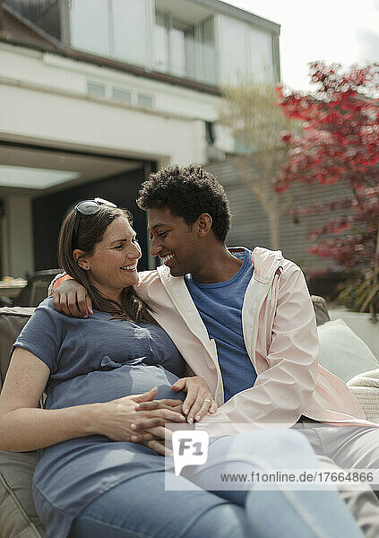 Glückliches  liebevolles  schwangeres Paar auf der Terrasse