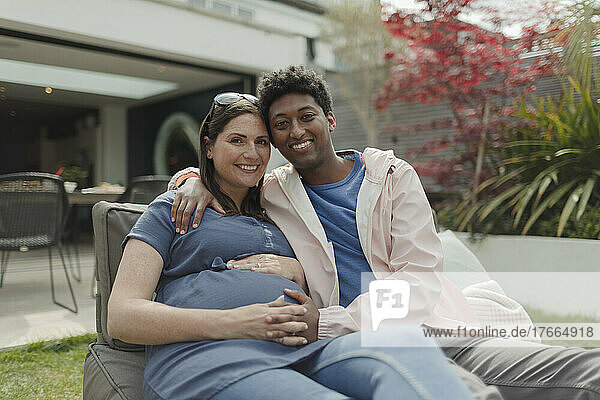 Porträt glückliches schwangeres Paar auf Veranda