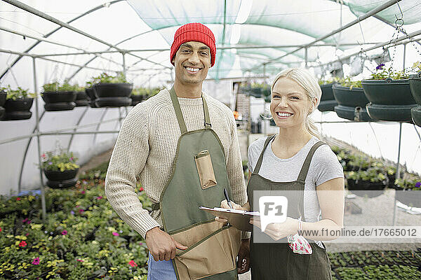 Porträt glücklicher Gärtnereibesitzer bei der Arbeit im Gewächshaus