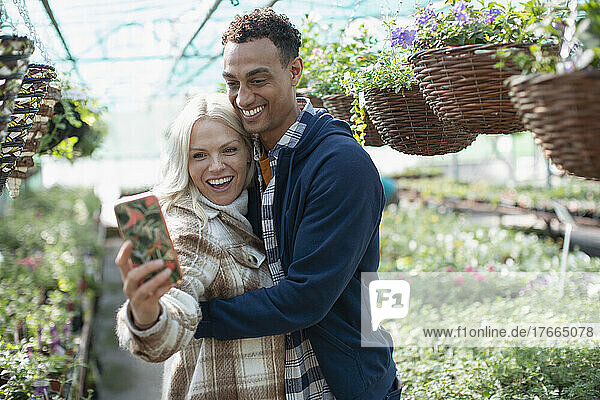 Glückliches Paar macht Selfie im Gartengeschäft