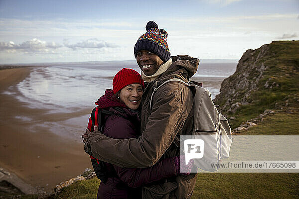 Portrait glücklich. Wanderer Paar umarmt auf Klippe mit Blick auf Strand