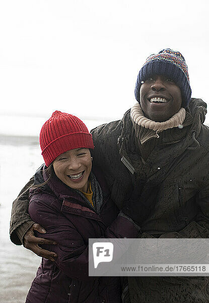 Happy playful couple in warm clothing hugging