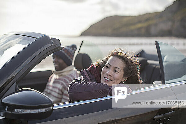Happy woman in convertible on beach
