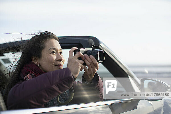 Frau mit Digitalkamera im Cabrio