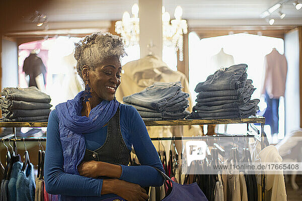 Glückliche ältere Frau beim Einkaufen in einer Kleiderboutique