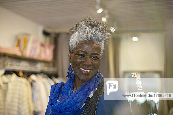 Portrait confident beautiful senior woman in clothing shop