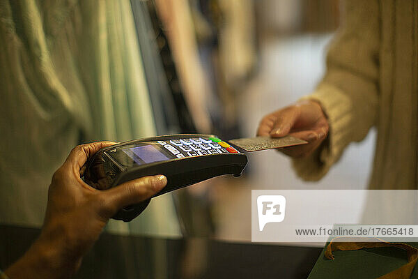 Close up Kunde mit Kreditkarte beim Bezahlen am Kreditkartenleser