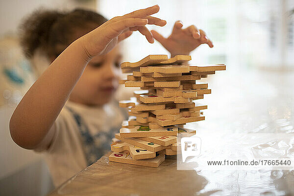 Girl stacking wood jigsaw pieces
