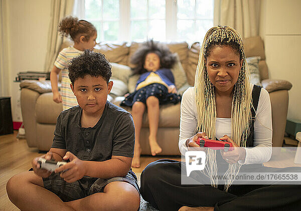 Portrait serious mother and son playing video game