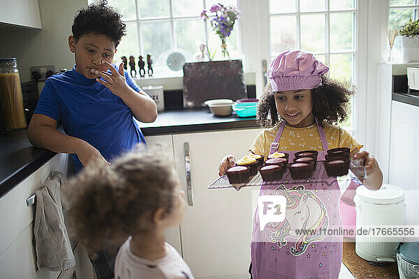 Kids baking cupcakes in kitchen