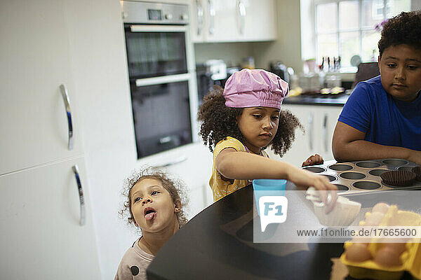 Brother and sisters baking cupcakes in kitchen