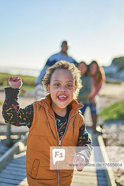 Portrait happy  cute boy with Down Syndrome smiling on beach path