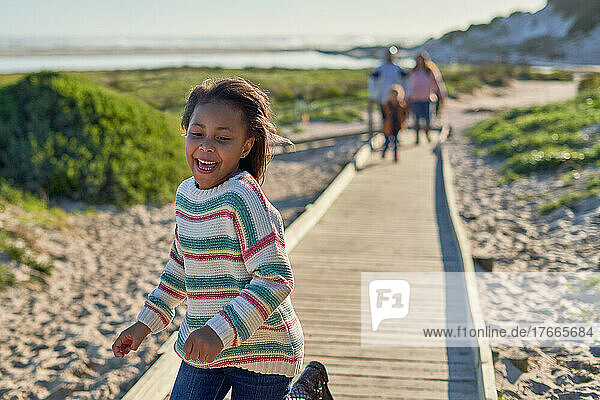 Happy girl running on beach boardwalk