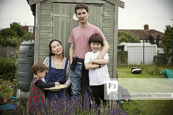 Portrait happy family at gardening shed