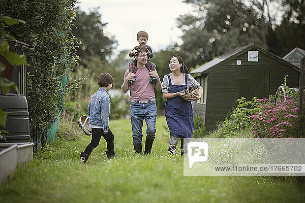 Happy family walking in grass in backyard garden