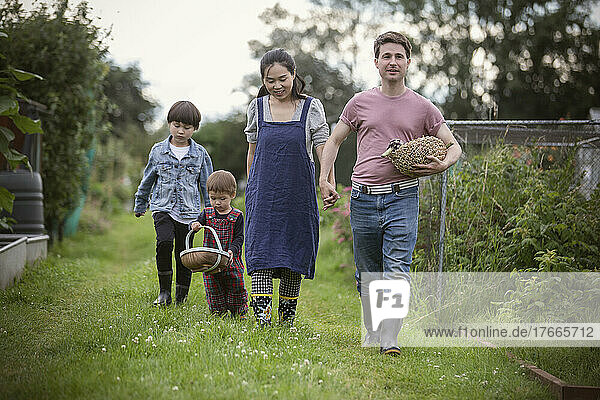 Family with baskets walking in garden grass