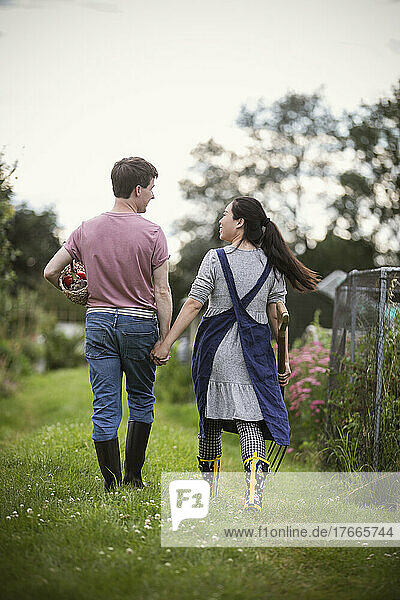 Couple holding hands and walking in garden