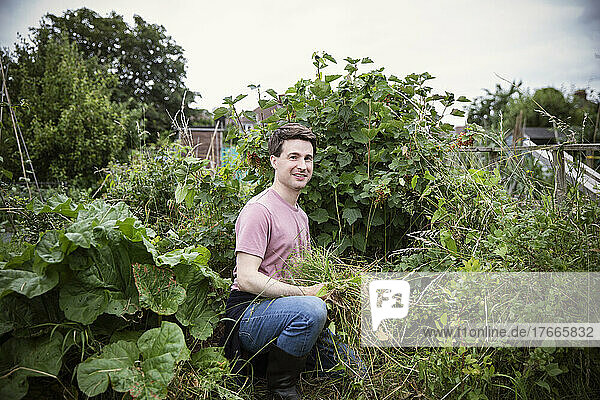 Portrait smiling man gardening in backyard garden