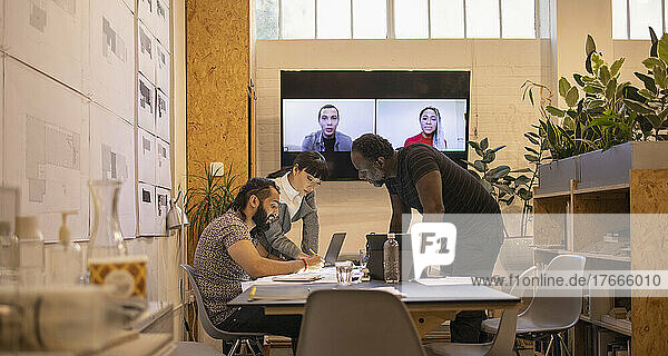 Architects video conferencing in office meeting