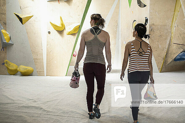 Female rock climbers with chalk bags in climbing center